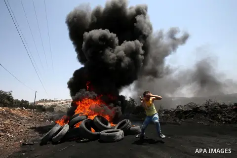Palestinian protesters burn tires during clashes with Israeli security forces following a protest against the expropriation of Palestinian land by Israel in the West Bank village of Kafr Qaddum, near the northern city of...