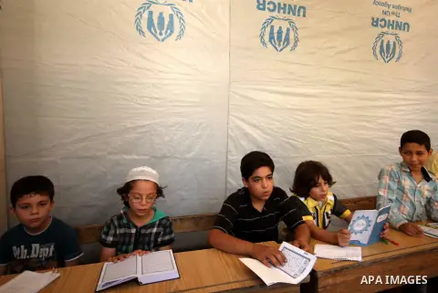 Fouad, a 11-year-old Syrian boy, sits in a classroom in a school in a rebel-controlled area of Aleppo, on August 8, 2015. Fouad works everyday following the school time to provide for his small family, as his father suff...