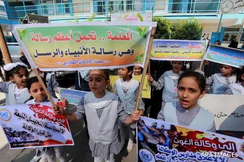 Palestinian children hold banners during a protest against the reduction of educational programs given by United Nations Relief and Works Agency (UNRWA) in Jabalia in the northern of Gaza strip on August 9, 2015. The UNR...