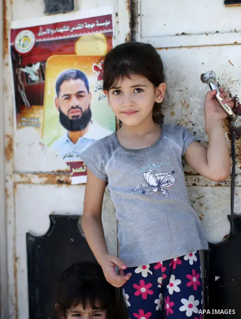 A relative of Palestinian prisoner in Israeli jails Mohammad Allan, stands next to his portrait at the entrance of his house in the village of Ainabos, south of Nablus in the occupied West Bank, on August 9, 2015. The Is...