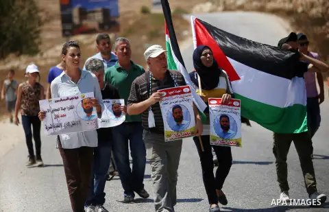 Protesters hold pictures of Palestinian prisoner Mohammad Allan, allegedly being held in an Israeli jail, during a protest in the West Bank village of Nabi Saleh, near Ramallah, 14 August 2015. According to the Palestini...