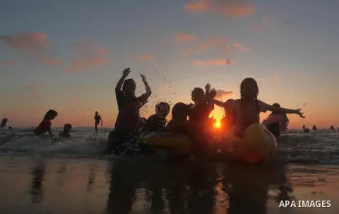 Palestinians enjoy a hot day at the beach of the Mediterranean Sea on the coast of Gaza City on August 14, 2015. Photo by Ashraf Amra