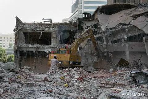 Egyptian workers use a bulldozer during the demolition of the headquarters of the once-dominant party of ex-president Hosni Mubarak that was torched during the 2011 uprising that toppled him, on August 16, 2015 in the ca...