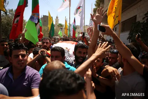 Mourners carry the body of 21-year-old Rafiq Taj, a Palestinian who was shot dead by Israeli forces after stabbing an Israeli border policeman, during his funeral procession on August 16, 2015 near the West Bank village...