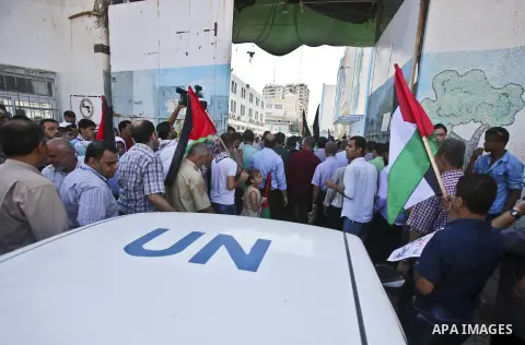 Palestinian children and teachers hold placards during a protest against the reduction of educational programs given by the United Nations Relief and Works Agency (UNRWA), in Gaza City August 17, 2015. Photo by Mohammed...