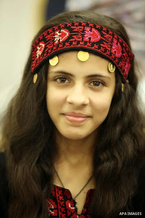 A Palestinian girl looks on as she watch members of musical band from "Edward Said National Conservatory of Music" perform in a festival of "Sea and Freedom" in Gaza city on August 22, 2015. Photo by Ashraf Amra