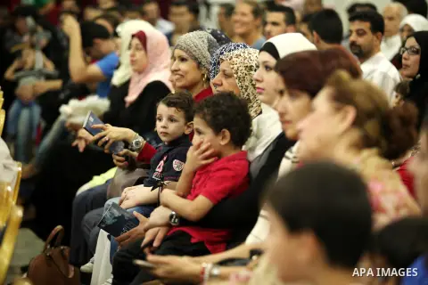Palestinians watch as members of musical band from "Edward Said National Conservatory of Music" perform in a festival of "Sea and Freedom" in Gaza city on August 22, 2015. Photo by Ashraf Amra