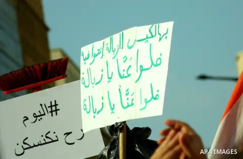 Lebanese protesters hold banners and national flags during a demonstration, against the ongoing trash crisis in the capital Beirut on August 22, 2015. Thousands of protesters, including children, gathered to protest the...