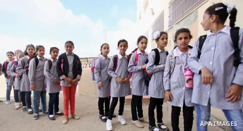 Palestinian students stand in a line at their school in the morning of the first day of the new year study in the West Bank village of Duma, near Nablus on August 24, 2015. Photo by Shadi Jarar'ah