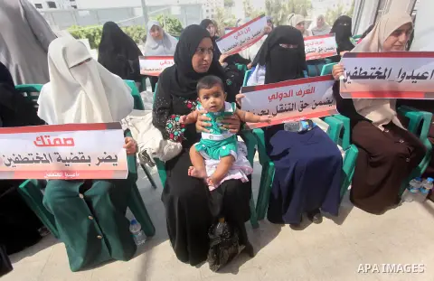 Palestinian families of abductees hold banners during a protest demanding released of four Palestinians were abducted in Egypt's Sinai Peninsula on Wednesday after the bus they were on was stopped by unidentified gunmen,...