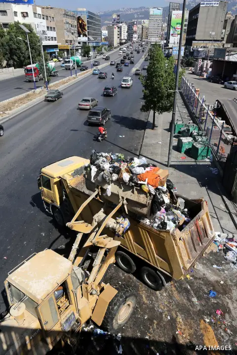 A Lebanese worker uses a bulldozer to remove waste from a street in Beirut's eastern suburb of Dora to a temporary location outside of the Lebanese capital on August 27, 2015. A trash crisis began in Lebanon after the go...