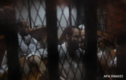 Egyptian suspects in the case of Suez terrorist group sit behind bars during during their trial, at a court, in Cairo, Egypt on August 29, 2015. Photo by Amr Sayed