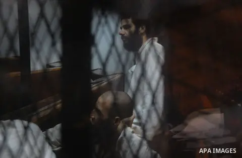 Egyptian suspects in the case of Suez terrorist group sit behind bars during during their trial, at a court, in Cairo, Egypt on August 29, 2015. Photo by Amr Sayed