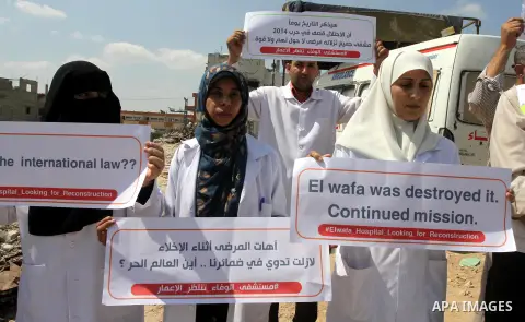 Palestinian Medical workers hold placards during a protest demanding reconstruction of El-Wafa hospital, which witnesses said was destroyed during a seven-week Israeli offensive, in the east of Gaza City on Sep. 01, 2015...
