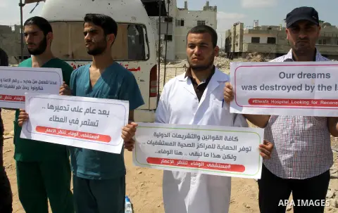 Palestinian Medical workers hold placards during a protest demanding reconstruction of El-Wafa hospital, which witnesses said was destroyed during a seven-week Israeli offensive, in the east of Gaza City on Sep. 01, 2015...