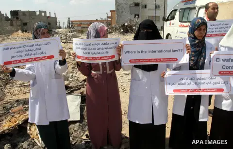 Palestinian Medical workers hold placards during a protest demanding reconstruction of El-Wafa hospital, which witnesses said was destroyed during a seven-week Israeli offensive, in the east of Gaza City on Sep. 01, 2015...