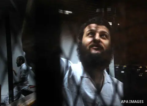 An Egyptian Muslim Brotherhood defendant sits behind the bars during his trial, along with ousted Islamist president Mohamed Morsi (unseen) in Cairo on Sep. 01, 2015. Cairo criminal court resumed proceedings in the 'Qata...