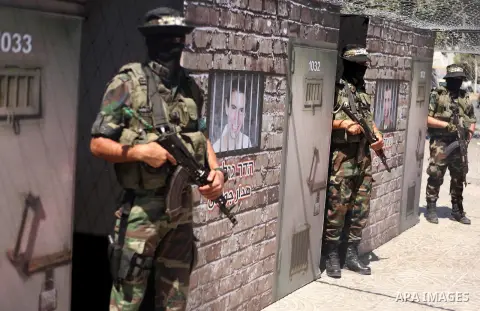 Palestinian militants of the Ezzedine al-Qassam Brigades, Hamas' armed wing, participate in the opening of the exhibition of the al-Qassam mock prisons, in Gaza city, on Sep. 02, 2015. Photo by Ashraf Amra