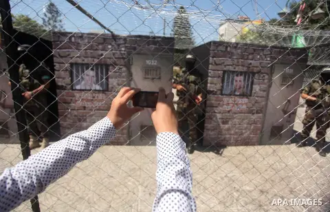Palestinian militants of the Ezzedine al-Qassam Brigades, Hamas' armed wing, participate in the opening of the exhibition of the al-Qassam mock prisons, in Gaza city, on Sep. 02, 2015. Photo by Ashraf Amra