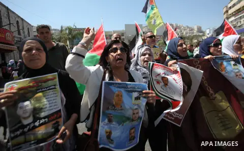 Palestinian protesters hold posters during a protest to show soldarity with prisoners, in the West Bank city of Nablus, on Sep. 03, 2015. Photo by Nedal Eshtayah