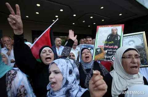 Palestinian protesters hold posters during a protest to show soldarity with prisoners, in the West Bank city of Nablus, on Sep. 03, 2015. Photo by Nedal Eshtayah