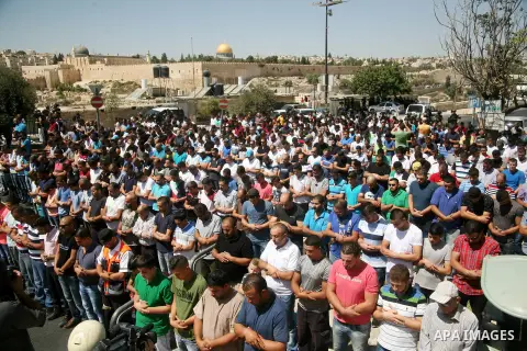Palestinian Muslim worshippers, under the age of 40 years old, perform the traditional Friday prayers on a street as Israeli police blocks the access to Al-Aqsa Mosque, outside the Old City walls in East Jerusalem on Sep...