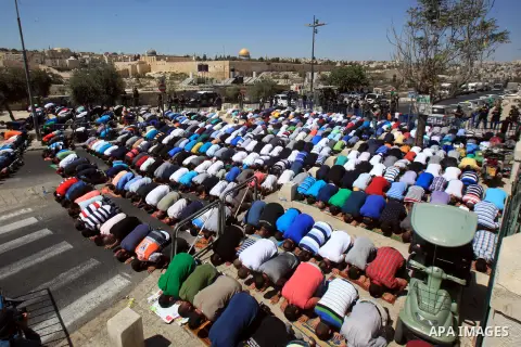 Palestinian Muslim worshippers, under the age of 40 years old, perform the traditional Friday prayers on a street as Israeli police blocks the access to Al-Aqsa Mosque, outside the Old City walls in East Jerusalem on Sep...