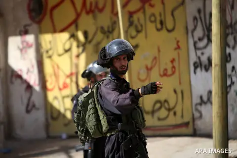 Israeli security forces take position during clashes with Palestinian protesters following a demonstration against the Israeli police raid on Jerusalem's al-Aqsa mosque on Tuesday at the Israeli Qalandia checkpoint near...