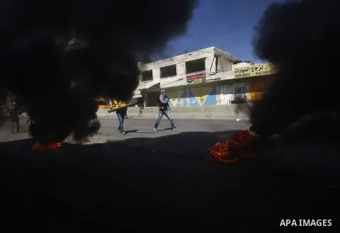 Palestinian protesters throw stones towards Israeli security forces during clashes following a demonstration against the Israeli police raid on Jerusalem's al-Aqsa mosque on Tuesday at the Israeli Qalandia checkpoint nea...