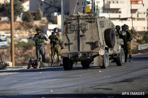 Israeli security forces take position during clashes with Palestinian protesters from the Jalazoun refugee camp following a demonstration against the Israeli police raid on Jerusalem's al-Aqsa mosque on Tuesday, on a roa...