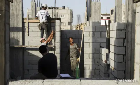 Palestinian construction workers work at the houses, which were destroyed during the 50-day Israeli war in the summer of 2014 in Gaza city on September 20, 2015. Photo by Abdallah Jadallah