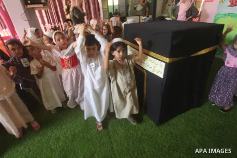 Palestinian children gather around a makeshift cube representing the holy Kaaba in Gaza city, on Sept. 21, 2015, as part of training children how to perform Hajj pilgrimage. Muslims from around the world flood Saudi city...