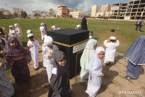 Palestinian children gather around a makeshift cube representing the holy Kaaba in Gaza city, on Sept. 21, 2015, as part of training children how to perform Hajj pilgrimage. Muslims from around the world flood Saudi city...