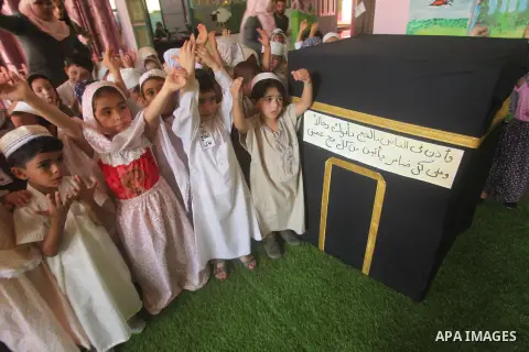 Palestinian children gather around a makeshift cube representing the holy Kaaba in Gaza city, on Sept. 21, 2015, as part of training children how to perform Hajj pilgrimage. Muslims from around the world flood Saudi city...