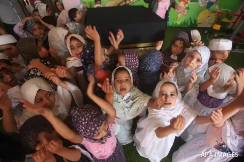 Palestinian children gather around a makeshift cube representing the holy Kaaba in Gaza city, on Sept. 21, 2015, as part of training children how to perform Hajj pilgrimage. Muslims from around the world flood Saudi city...