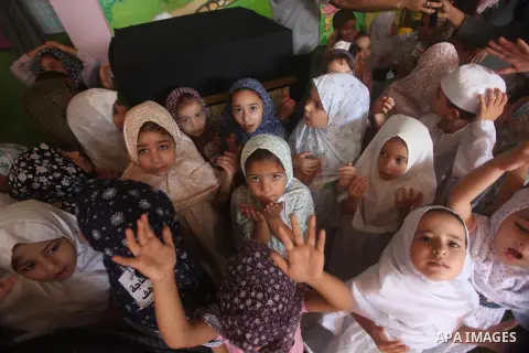 Palestinian children gather around a makeshift cube representing the holy Kaaba in Gaza city, on Sept. 21, 2015, as part of training children how to perform Hajj pilgrimage. Muslims from around the world flood Saudi city...