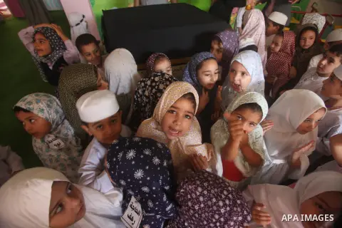 Palestinian children gather around a makeshift cube representing the holy Kaaba in Gaza city, on Sept. 21, 2015, as part of training children how to perform Hajj pilgrimage. Muslims from around the world flood Saudi city...