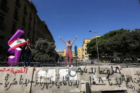 Lebanese anti-government protesters take part in a protest on a road leading to the parliament, where leading figures of Lebanon's main political parties meet for the third time in an effort to end the paralysis plaguing...