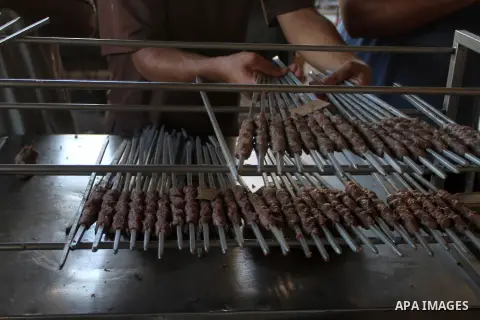 A Palestinian vendor sells grilled meat "Kebabs" in his shop at a market in Rafah in the southern Gaza Strip September 26, 2015, on the third day of Eid al-Adha or the feast of sacrifice. The religious festival, celebrat...