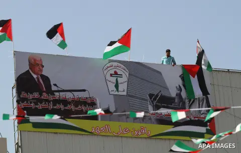 A Palestinian man stands nexto to his national flags during an event to support Palestinian President Mahmoud Abbas in the West Bank city of Nablus on September 30, 2015. Abbas has circulated a hard-hitting critique of a...