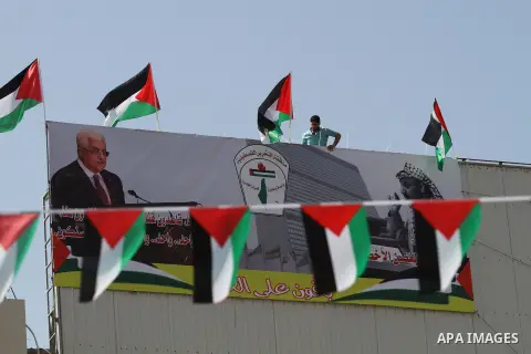 A Palestinian man stands nexto to his national flags during an event to support Palestinian President Mahmoud Abbas in the West Bank city of Nablus on September 30, 2015. Abbas has circulated a hard-hitting critique of a...