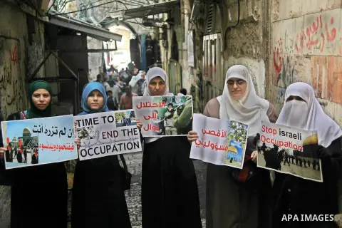 Palestinian women from the so-called Murabitat group carry placards and shout slogans in front of Israeli security forces during a protest against Jewish groups visiting the Al-Aqsa mosque compound and against preventing...