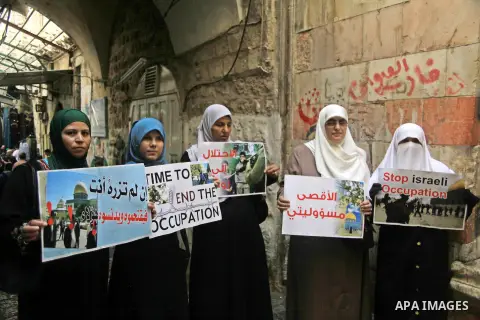 Palestinian women from the so-called Murabitat group carry placards and shout slogans in front of Israeli security forces during a protest against Jewish groups visiting the Al-Aqsa mosque compound and against preventing...