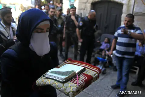 A Palestinian woman from the so-called Murabitat group, holds a copy of the holy Quran during a protest against Jewish groups visiting the Al-Aqsa mosque compound and against preventing them from entering the shrine on S...
