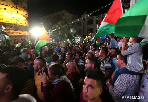Palestinians celebrate following the Palestinian President Mahmoud Abbas' speech at the General Assembly at the United Nations, in the West Bank city of Ramallah on September 30, 2015. Demonstrating a new level of tensio...