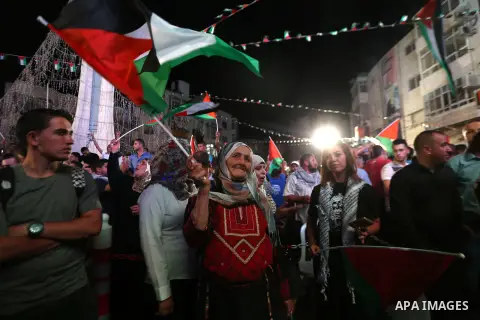 Palestinians celebrate following the Palestinian President Mahmoud Abbas' speech at the General Assembly at the United Nations, in the West Bank city of Ramallah on September 30, 2015. Demonstrating a new level of tensio...