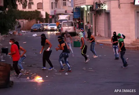Palestinian protesters throw stones towards Israeli security forces during clashes over the Al-Aqsa mosque compound, close to the Israeli manned checkpoint of Hezma in the Israeli occupied West Bank, between Jerusalem an...