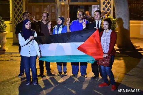 Egyptians hold Palestinian flag in front of Arab league headquarters coinciding with the Palestinian President Mahmoud Abbas' speech at the United Nations headquarters in New York, in Cairo on September 30, 2015. Earlier...