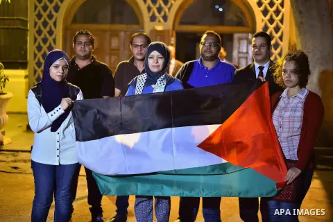 Egyptians hold Palestinian flag in front of Arab league headquarters coinciding with the Palestinian President Mahmoud Abbas' speech at the United Nations headquarters in New York, in Cairo on September 30, 2015. Earlier...