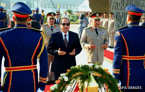 A handout picture released by the Egyptian Presidency shows Egyptian President Abdul Fattah al-Sisi (C) paying his respects in front of the grave of former Egyptian President Gamal Abdel Nasser during a ceremony at the m...